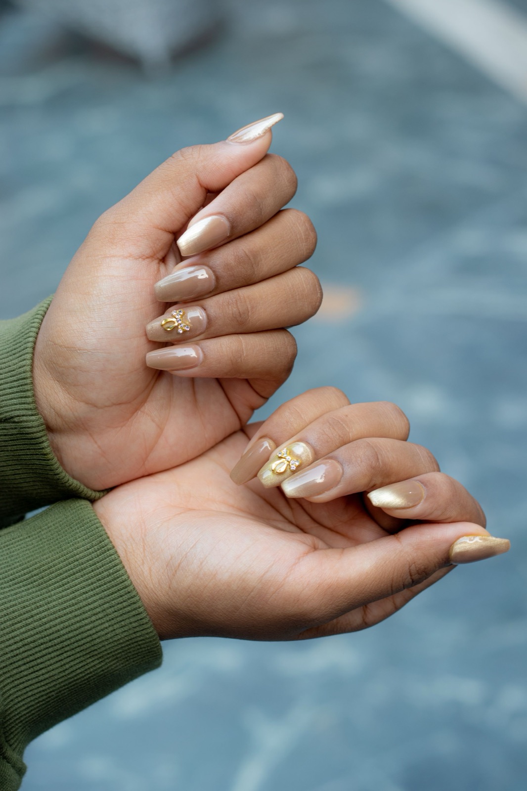 Chrome powder nails with a mirror metallic finish and gold leaf accent detail
