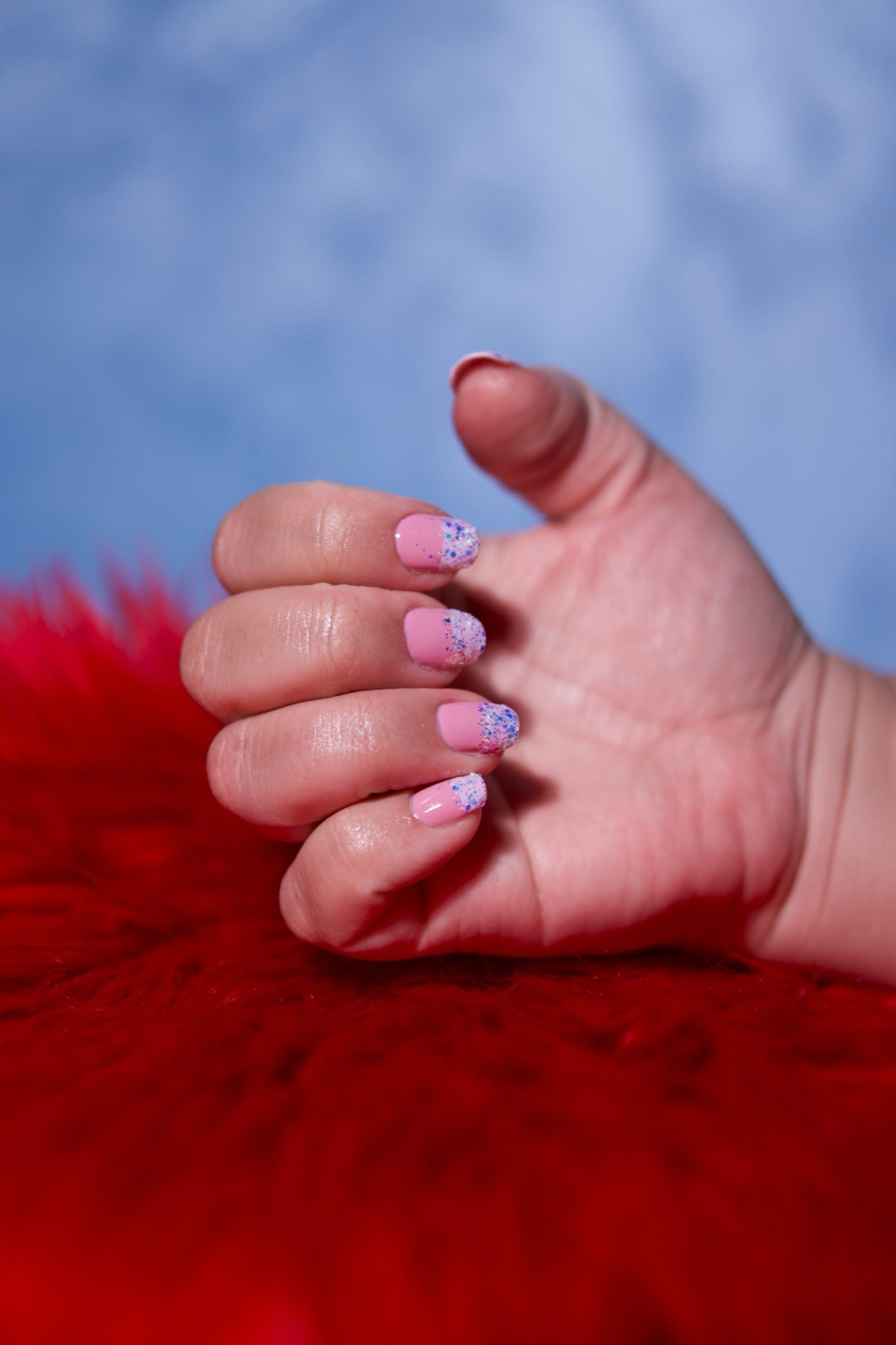 Custom detailed nail art with glitter gradient and hand-painted accents on long shaped nails