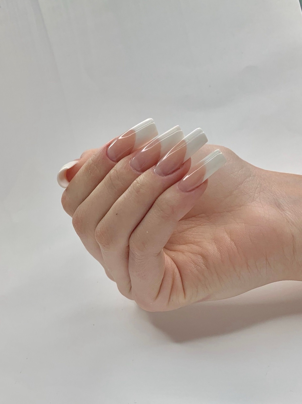 Long coffin shaped nails with a soft French ombre milky tip