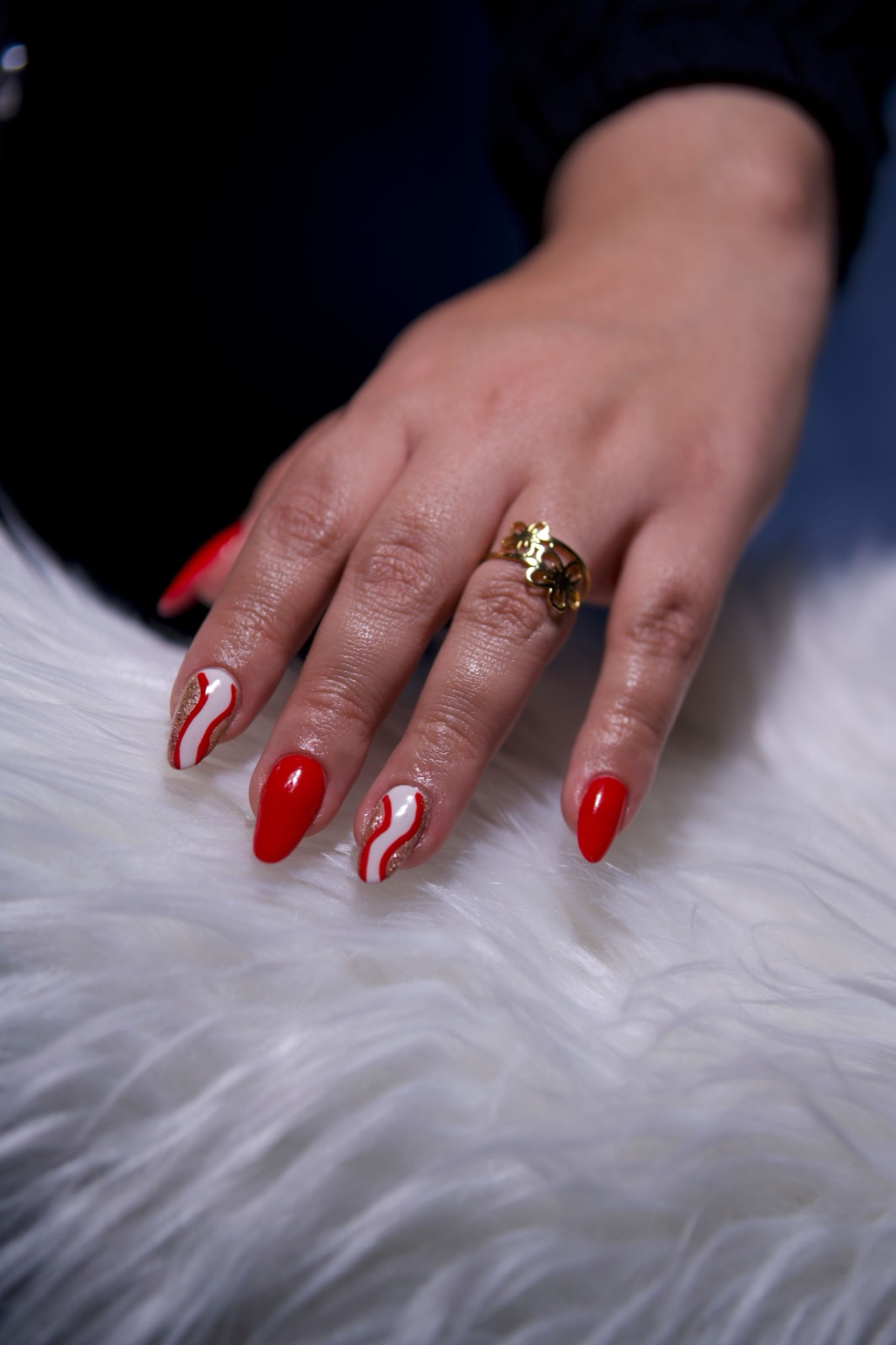 Red and white hand-painted nail art with a graphic contrast pattern